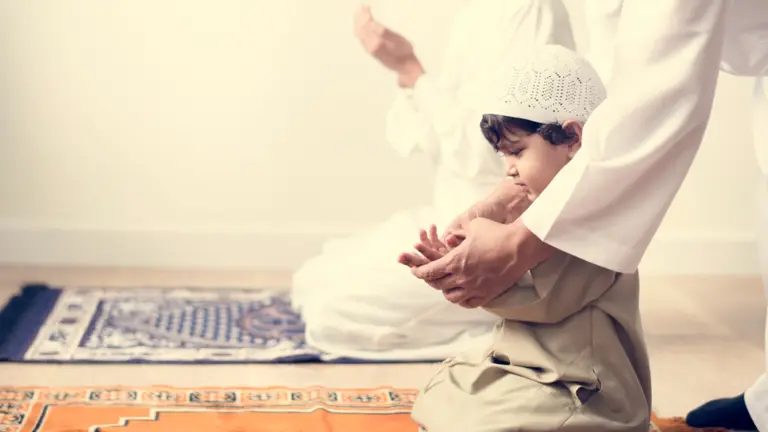 Child learning prayer with his father
