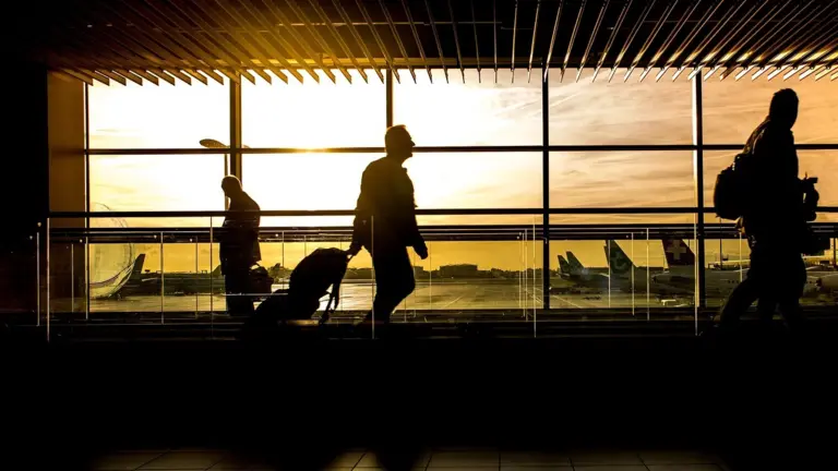 Travelers in an airport at sunset