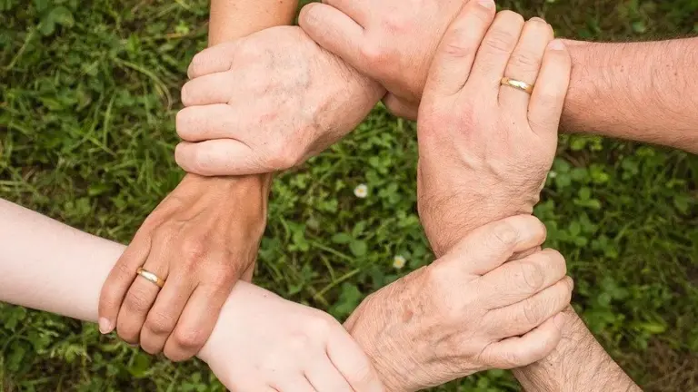 Hænder fra flere generationer samlet i en cirkel