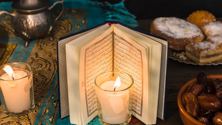 Open Quran with candle and dates