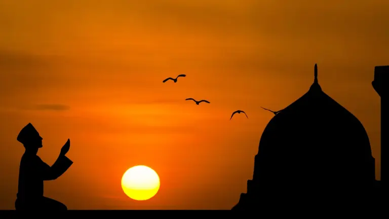 Silhouette of a man making dua at sunset