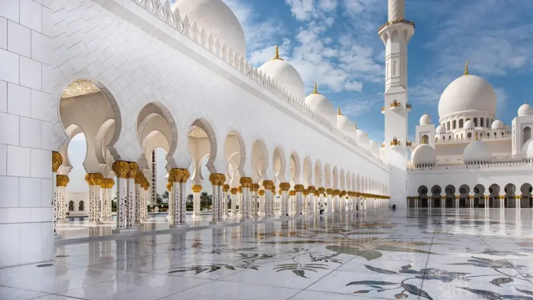 White grand mosque with bright arches and domes