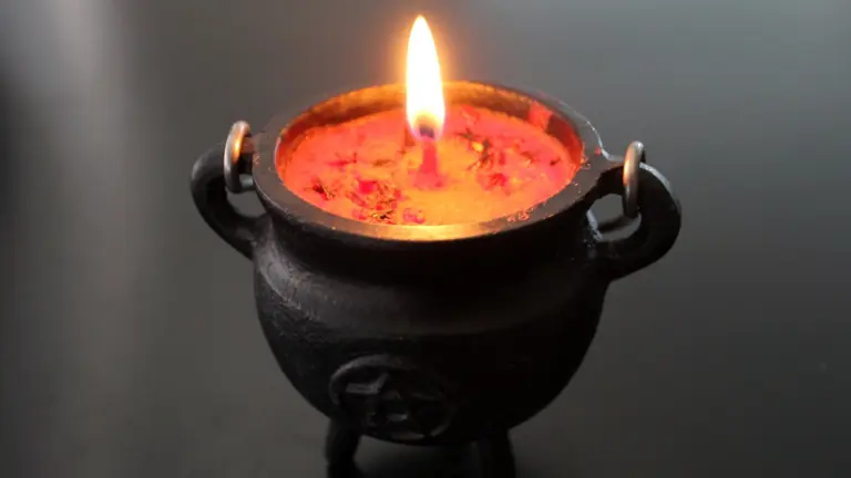 Lit candle in a dark container