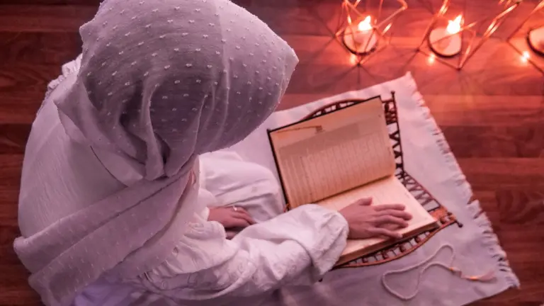Woman reading the Quran in a prayer space