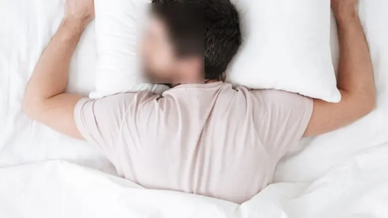 Person sleeping on their stomach in bed