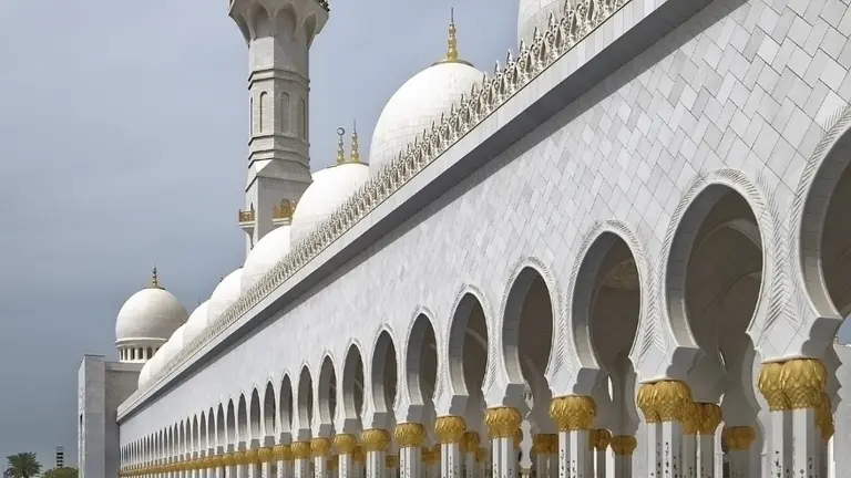 Hvid moské med minaret og kupler i De Forenede Arabiske Emirater