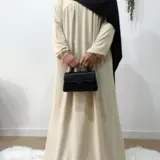 Muslim woman wearing a beige abaya and black khimar