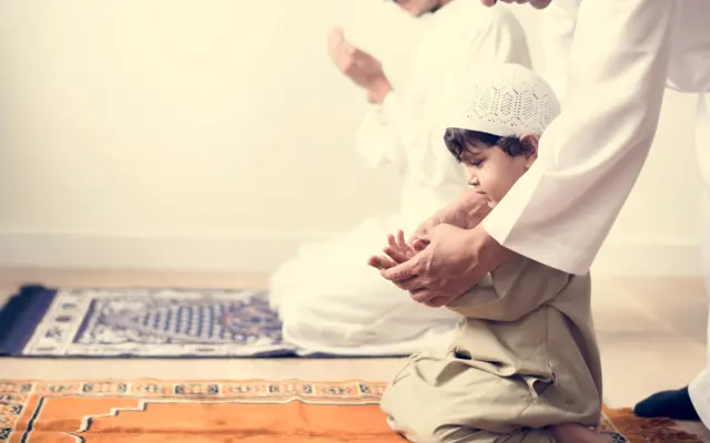 Kind lernt mit seinem Vater das islamische Gebet
