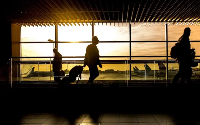 Travelers in an airport at sunset