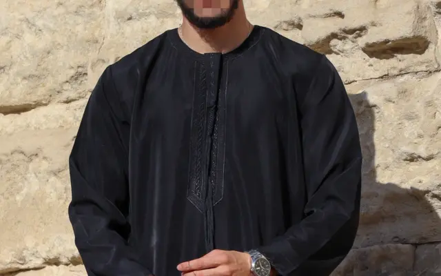 Mann trägt einen schwarzen Qamis