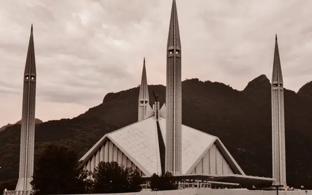 Moderne Moschee mit Minaretten vor einer Berglandschaft