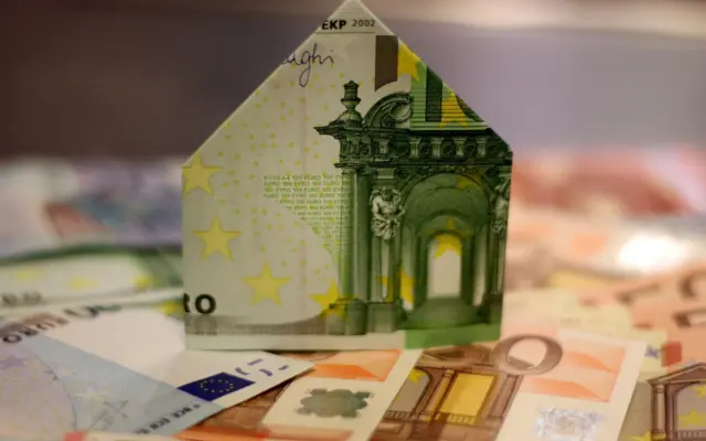 Haus aus Geldscheinen als Symbol für islamische Immobilienfinanzierung