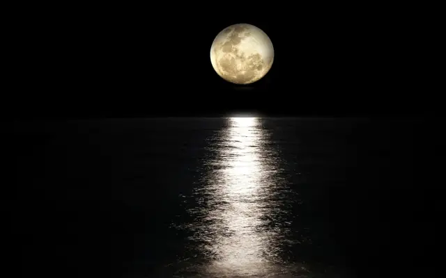 Full moon reflecting on the sea at night