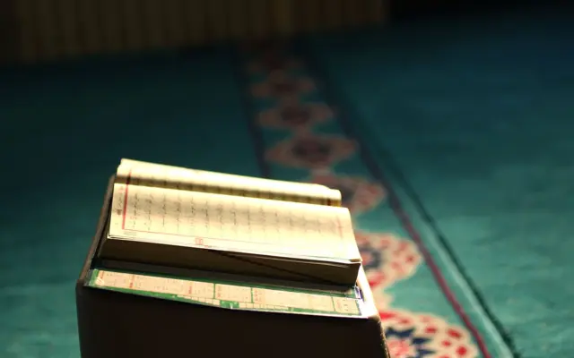 Åben Koran på et bedetæppe