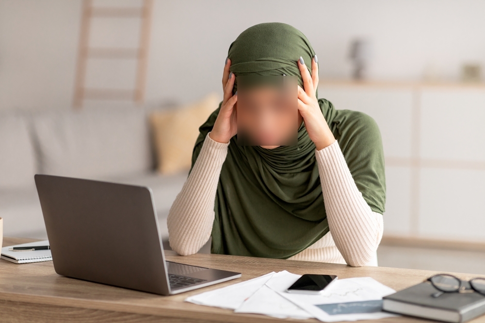 Stressed woman at a laptop, illustrating anxiety